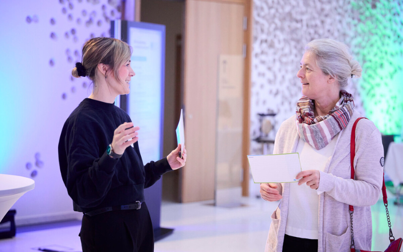 zwei Frauen stehen auf einer Veranstaltung zusammen und unterhalten sich