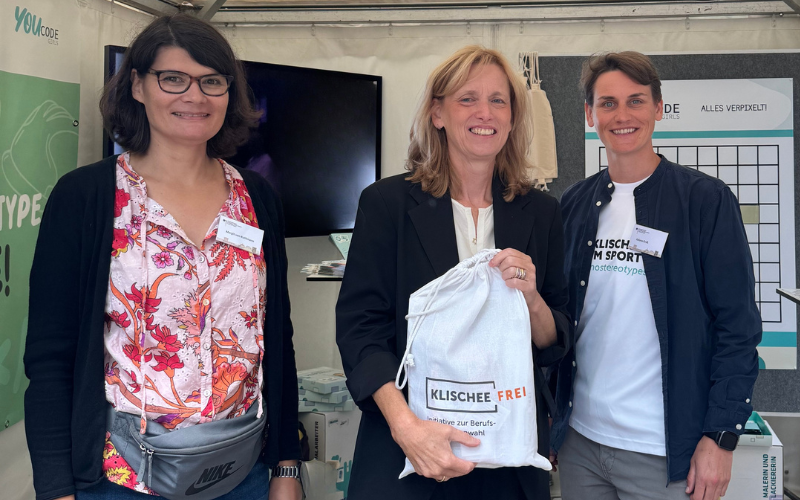 Ein Gruppenfoto mit der Bildungsministerin Karin Prien, Juliana Groß und Margit Kuhlmann vor dem Stand.