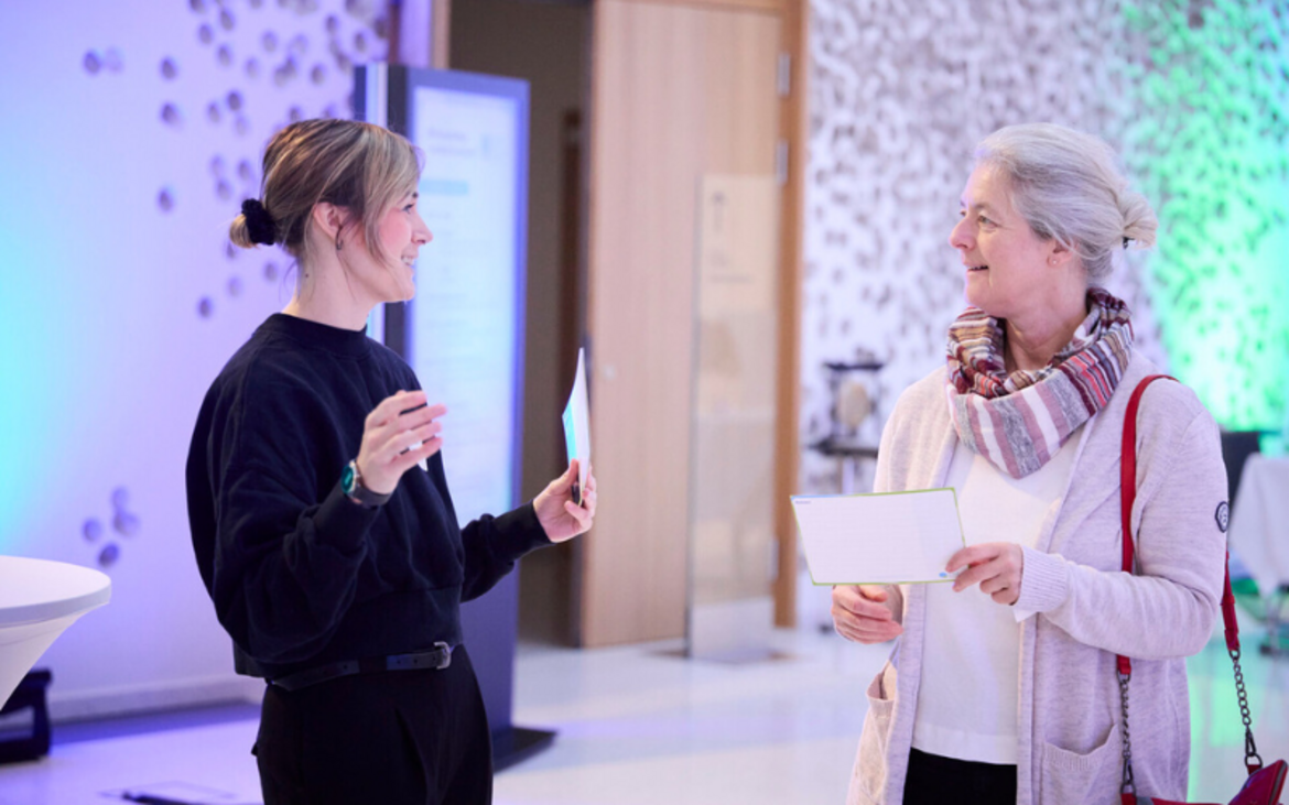 zwei Frauen stehen auf einer Veranstaltung zusammen und unterhalten sich