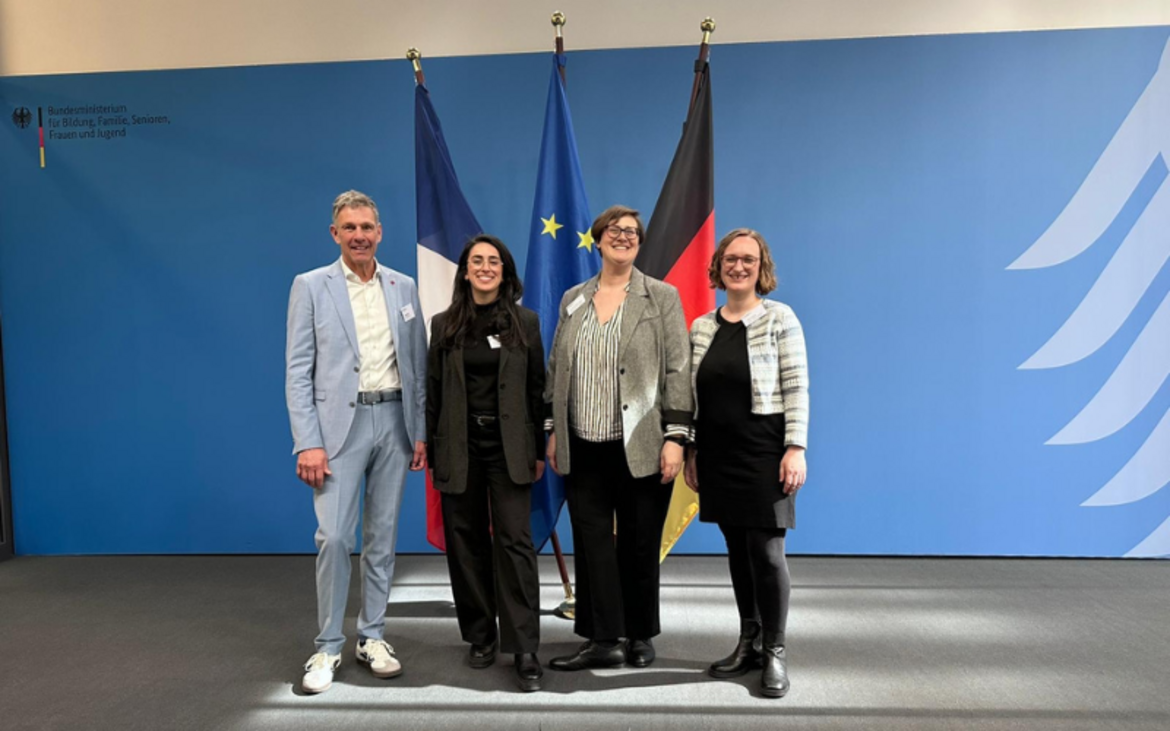 Miguel Diaz, Arzu Sahin, Dr. Anna Voigt und Tabea Schroer vor der französischen, europäischen, und deutschen Flagge