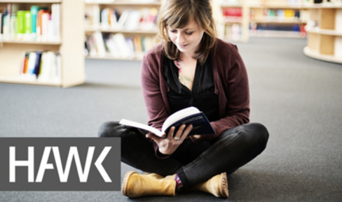 Studentin liest in einer Bibliothek