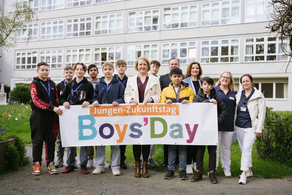 Lisa Paus mit Boys'Day-Teilnehmern vor einem Pflegeheim