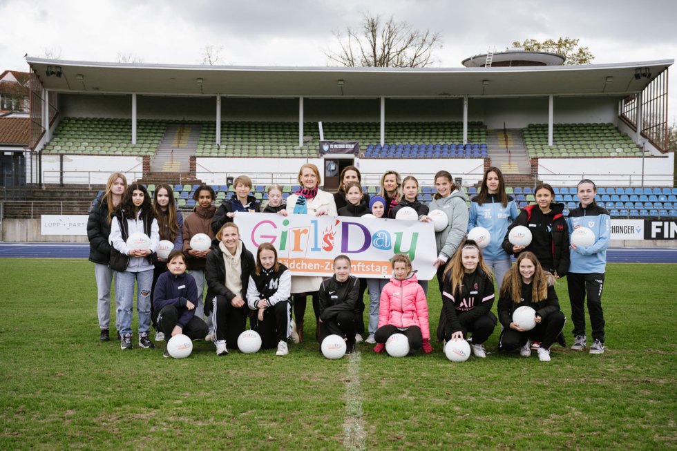 Lisa Paus mit Girls'Day-Teilnehmern auf dem Fußballplatz